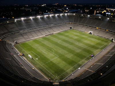 Fu&szlig;ballstadion bei Nacht mit Flutlicht und perfekt gr&uuml;nem Rasen f&uuml;r Sportwetten bei Golisimo