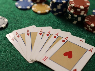 Blackjack Karten auf gr&uuml;nem Filz-Tisch mit Chips in dunkler Casino-Beleuchtung
